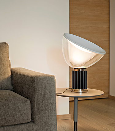 Moderne designlampe som gir mykt omgivelseslys ved siden av en moderne sofa