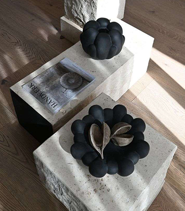 Kunstneriske svarte keramiske boller utstilt på minimalistiske steinbord med naturlige teksturer