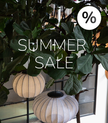 Stoffpendler foran frodig grønt med Summer Sale-melding.