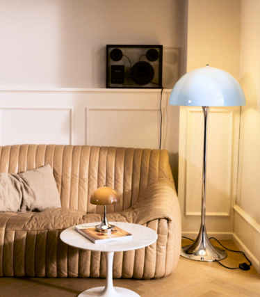 Louis Poulsen Panthella gulvlampe og bordlampe i en lun stue med skinnsofa